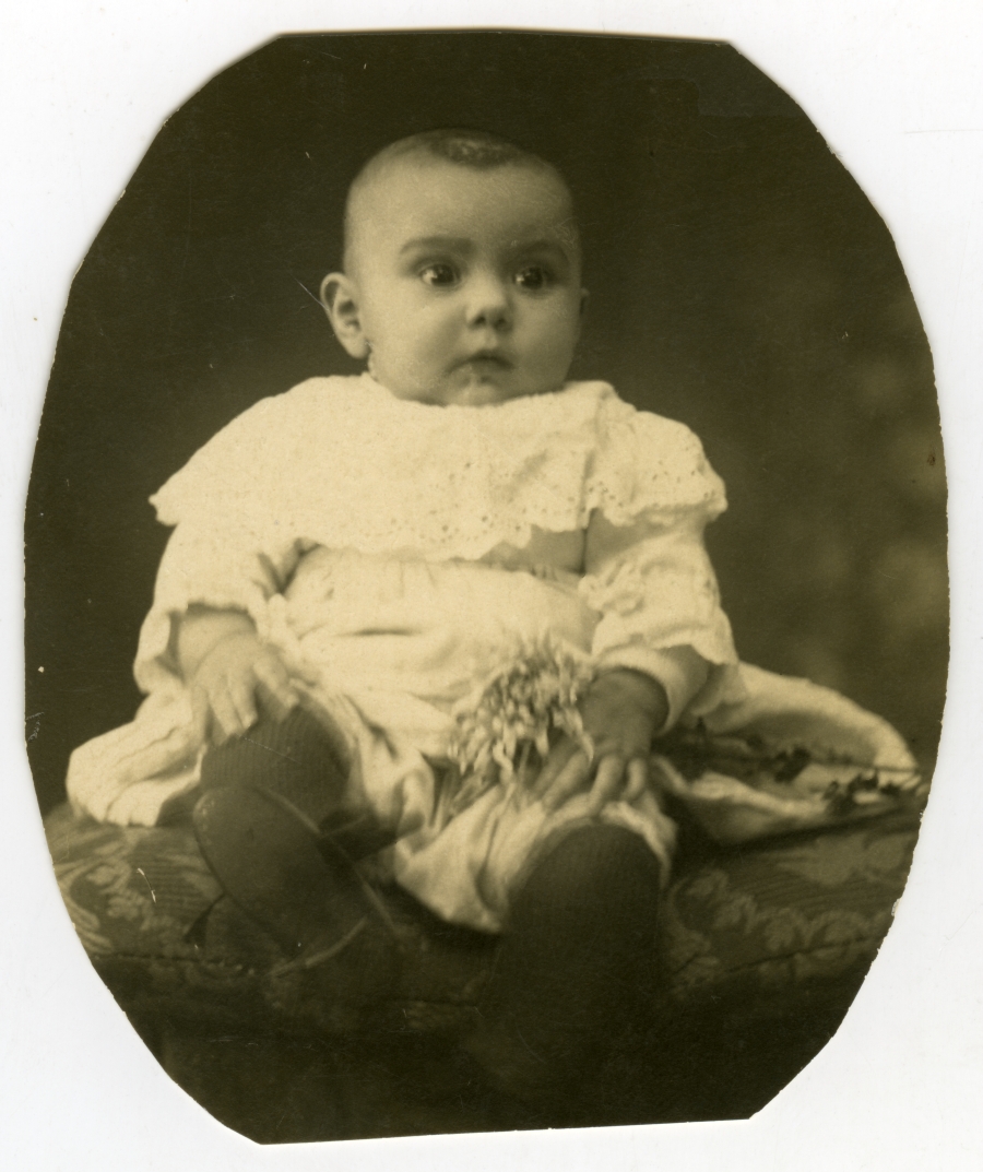 Retrato de un bebé vestido con un traje de color claro