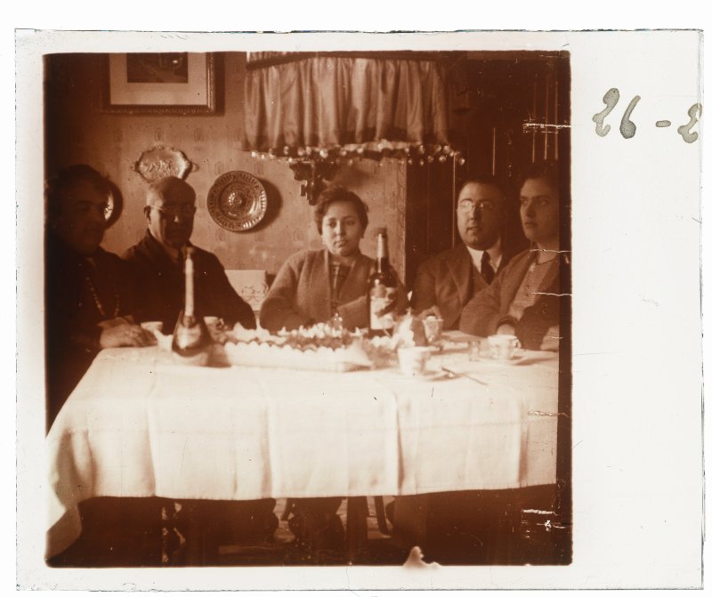 Grupo familiar sentado a una mesa con bebidas y un pastel