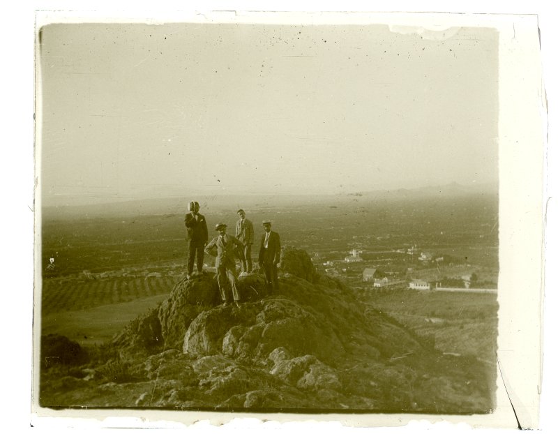 Retrato de cuatro hombres tomado desde la cima de un cerro