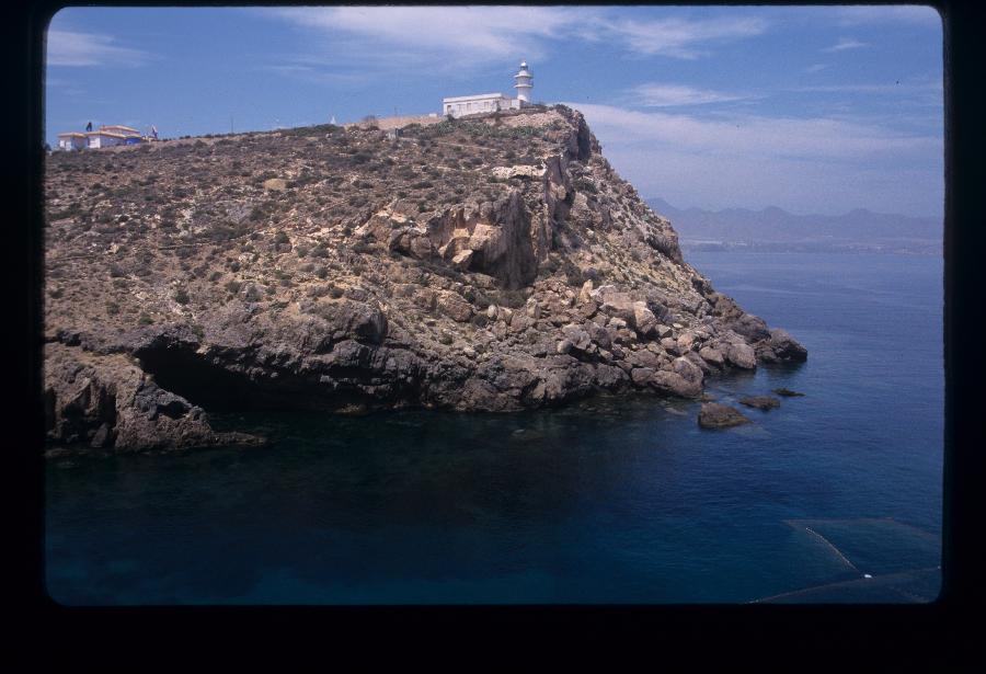 Vista del faro del Puerto de Mazarrón desde la cala de Moro Santo