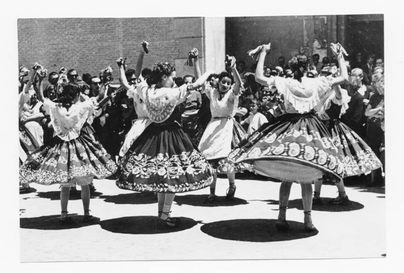 Grupo de mujeres de un grupo folclórico bailando en una calle de Murcia.