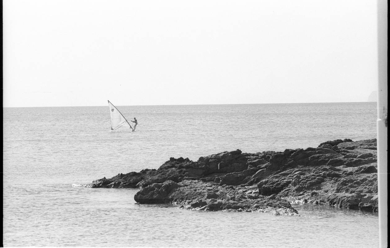 Un aficionado practicando windsurf  en una playa de la Región de Murcia.