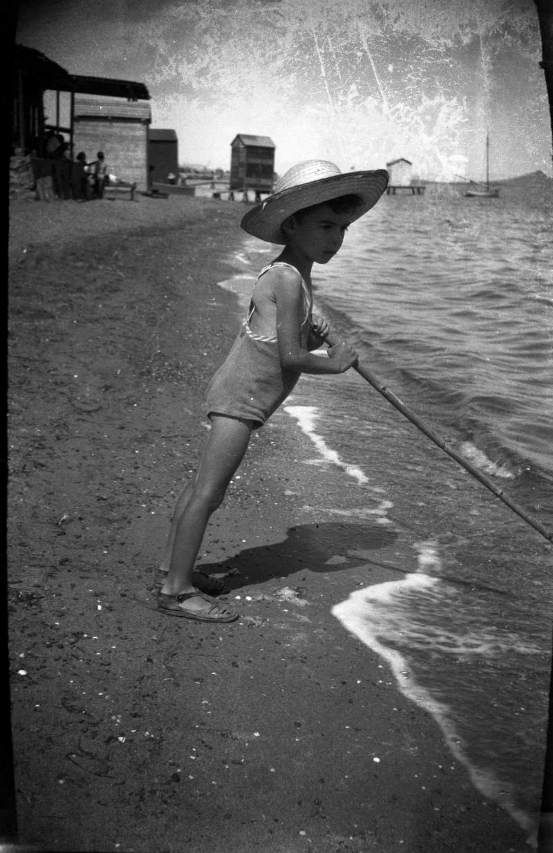 Niño con sombrero de paja y traje de baño en una playa del Mar Menor