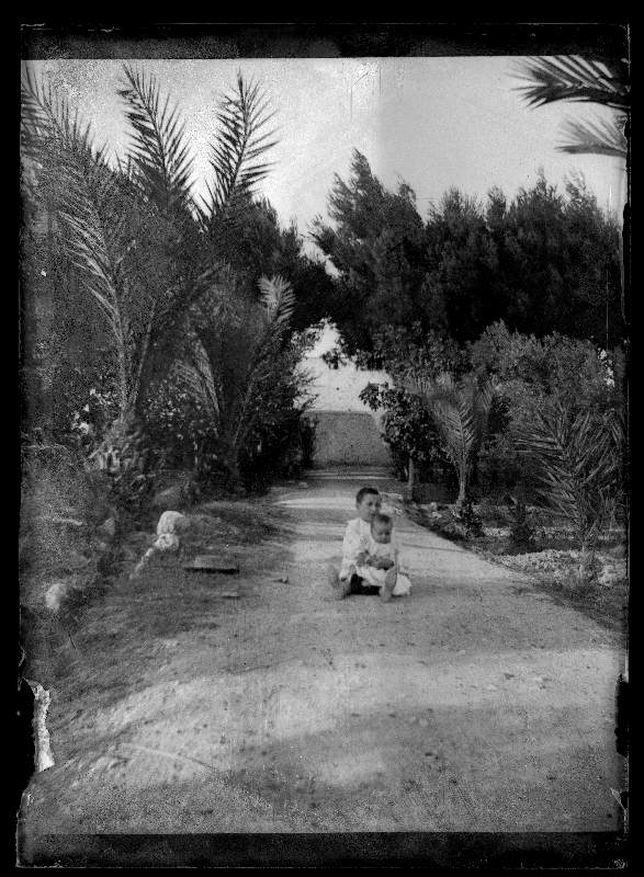 Retrato de los hermanos Manuel y Antonio Moxó Ruano en un jardín con palmeras.