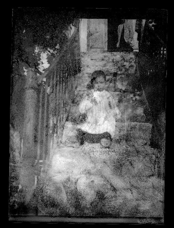 Retrato de un niño en una escalera del exterior de una casa