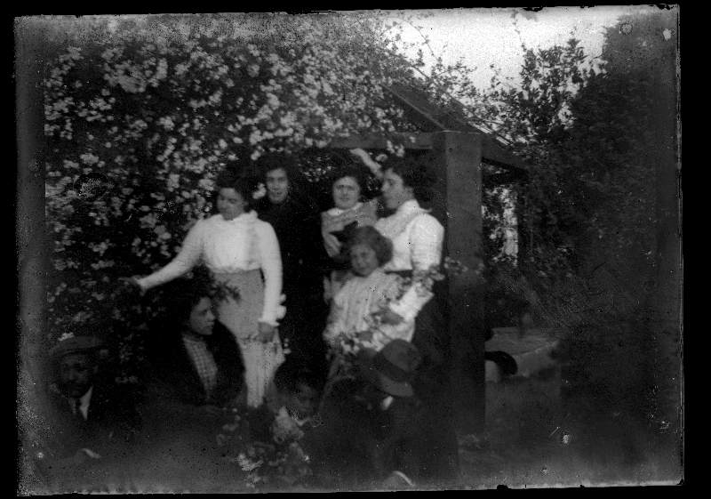 Retrato de un grupo de adultos y niños en un jardín junto a un pozo