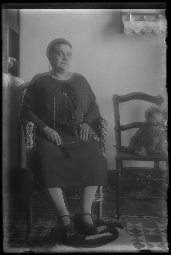 Retrato de una mujer sentada en el interior de una vivienda