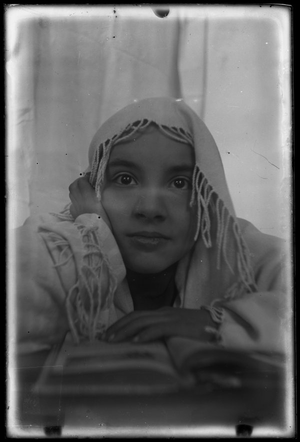 Retrato de primer plano de Josefina, con un pañuelo en la cabeza, frente a un libro