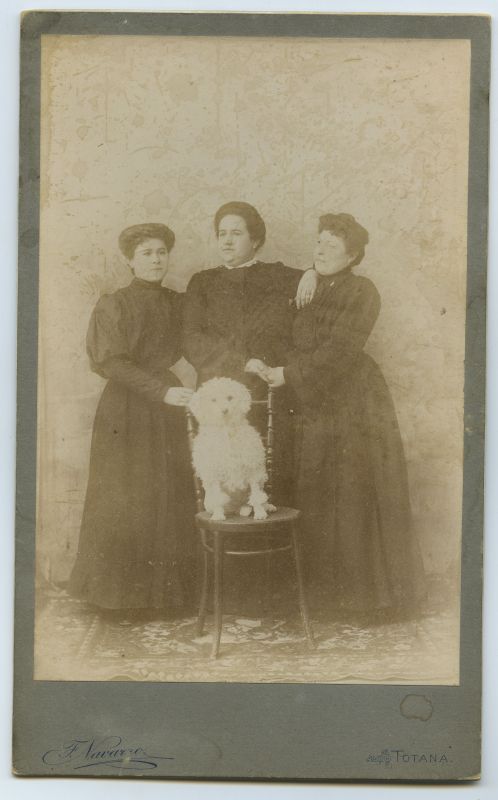 Retrato de tres mujeres con un perro.