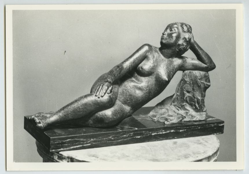Escultura en bronce de mujer recostada sobre una roca, obra de Juan González Moreno.