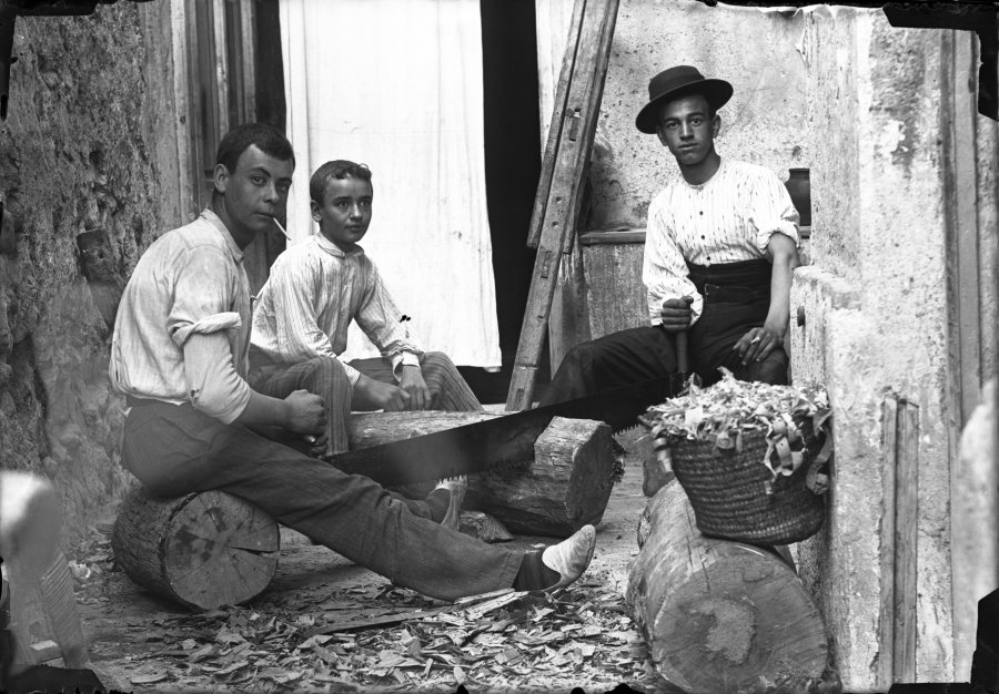 Retrato de tres adolescentes trabajando en el patio de un taller de carpintería
