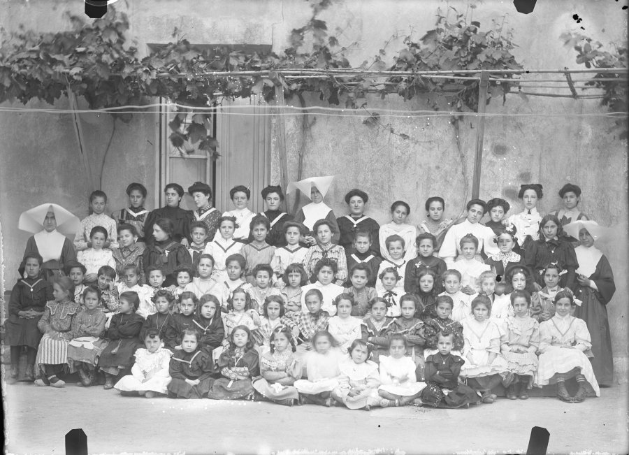Retrato en exterior de un grupo de alumnas de distintas edades acompañadas por sus profesoras y algunas monjas