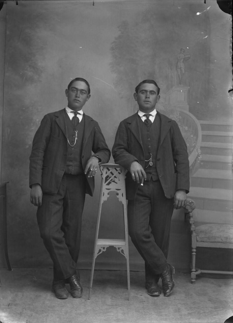 Retrato de estudio de dos hermanos posando en la misma posición