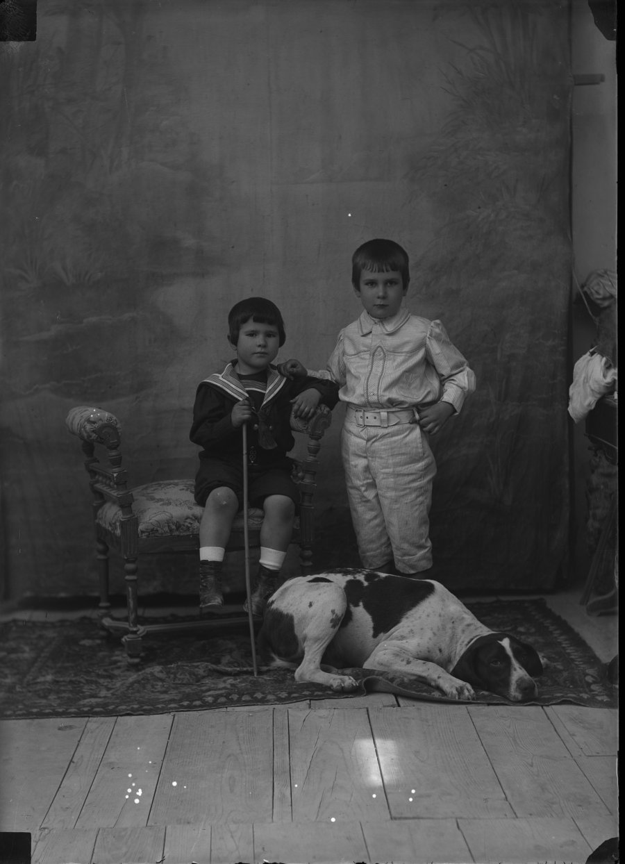 Retrato de estudio de dos niños con un perro