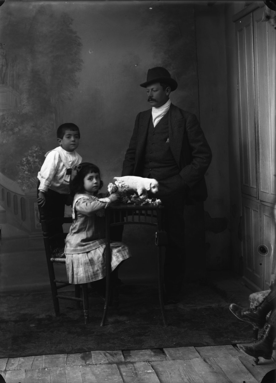 Retrato de estudio de un hombre con dos niños y un cachorro de perro