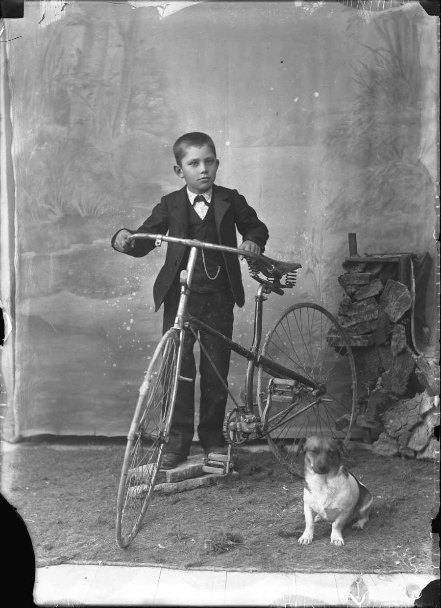 Retrato de estudio de un niño con bicicleta y perro