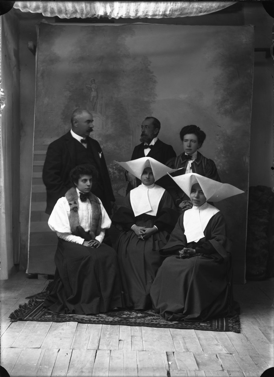 Retrato de estudio de un grupo de hombres y mujeres, entre las que se encuentran dos monjas