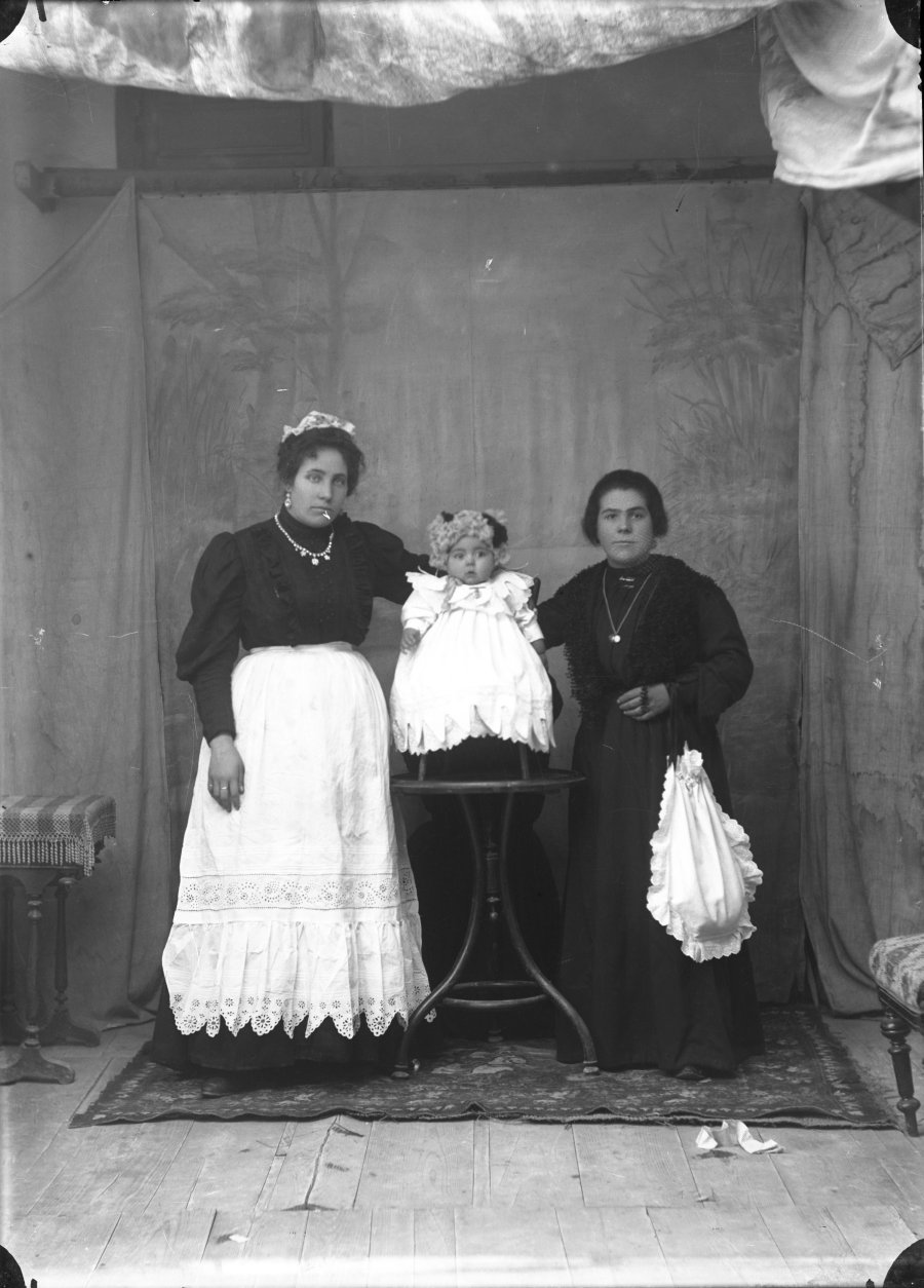 Retrato de estudio de dos mujeres jóvenes con bebé de pocos meses