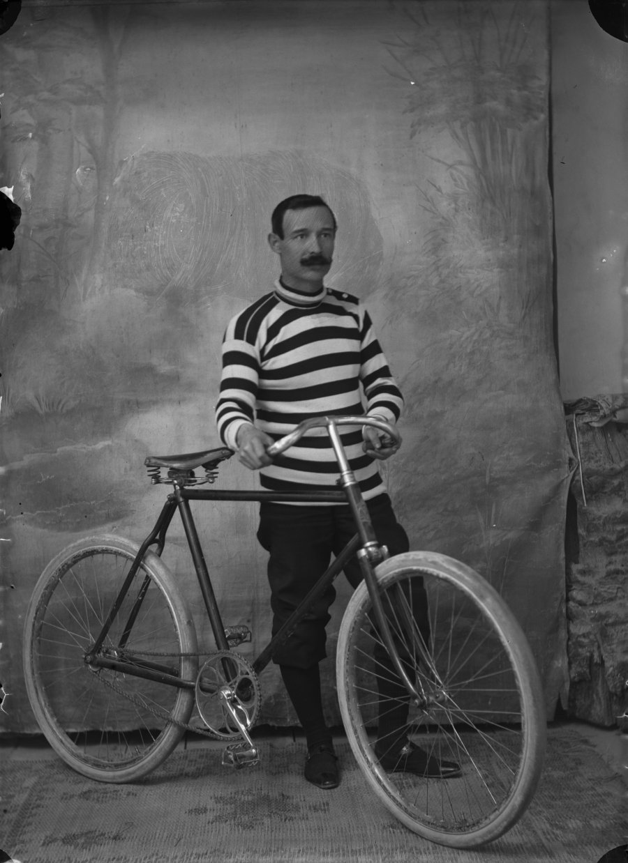 Retrato de estudio de un hombre con bicicleta vestido con jersey de rayas