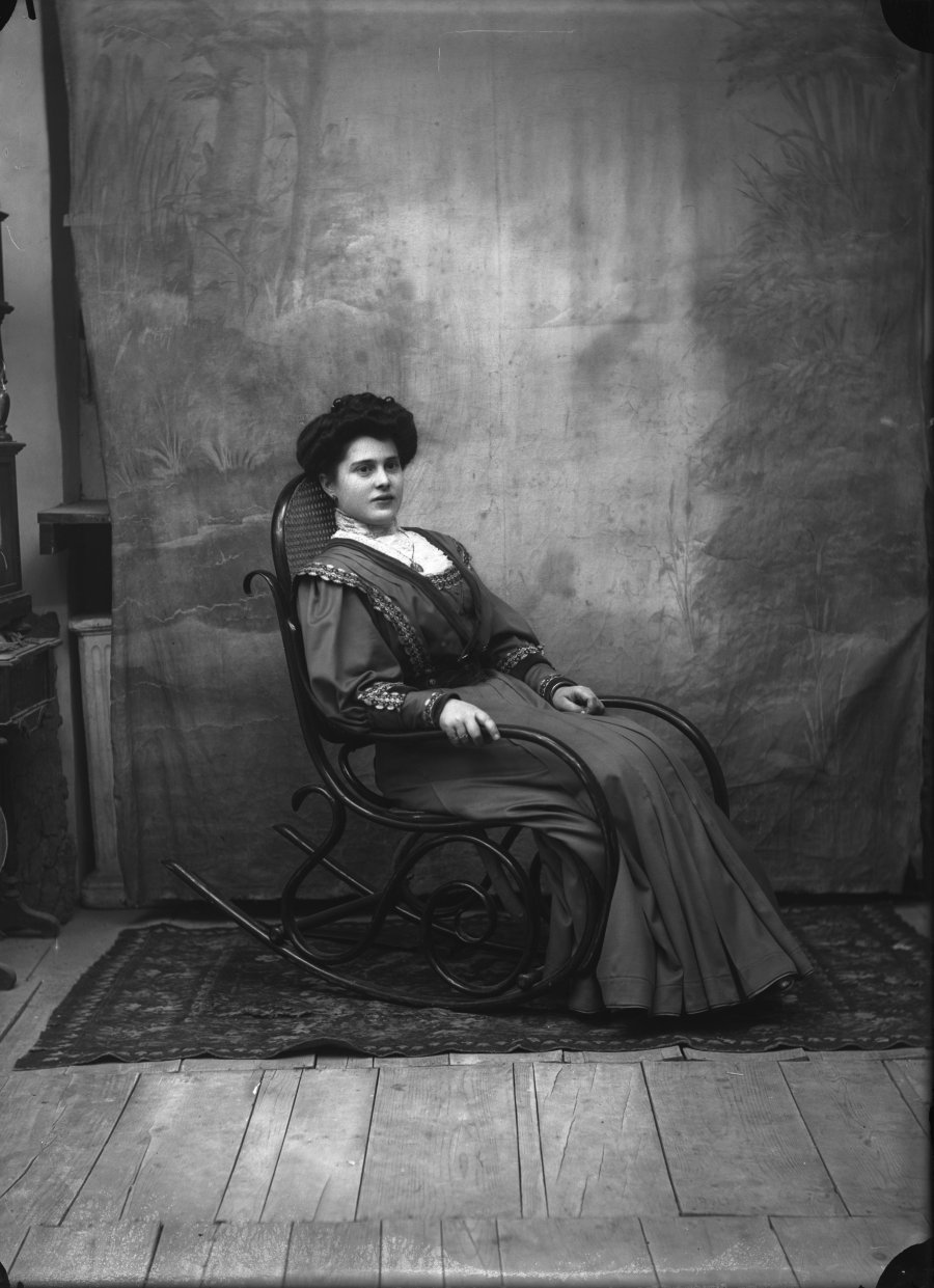 Retrato de estudio de una mujer joven sentada en mecedora