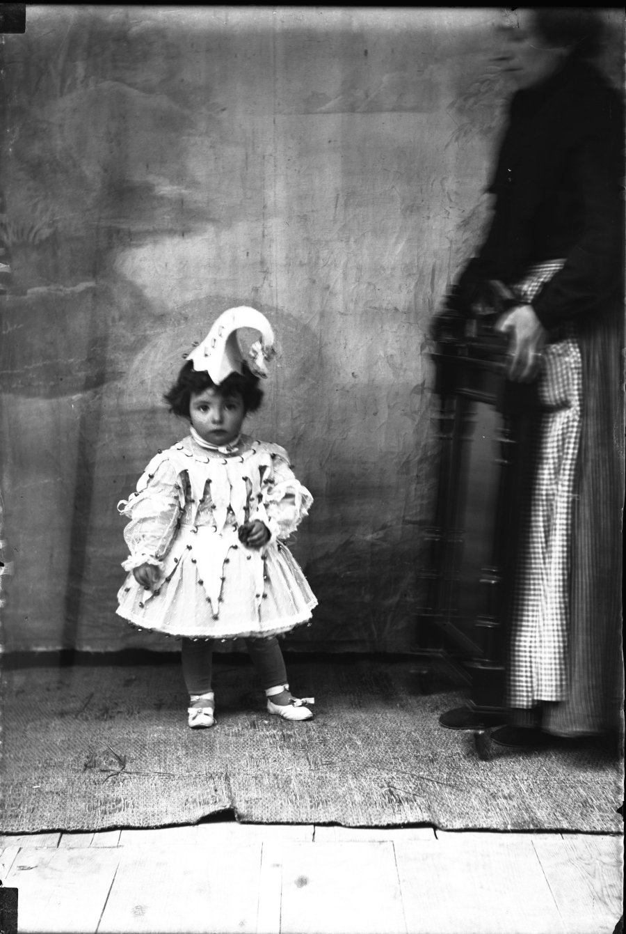 Retrato de estudio de una niña disfrazada de arlequín