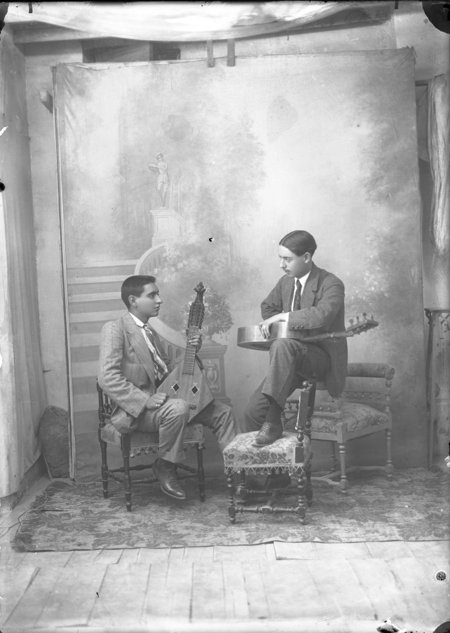 Retrato de estudio de dos hombres jóvenes con instrumentos musicales