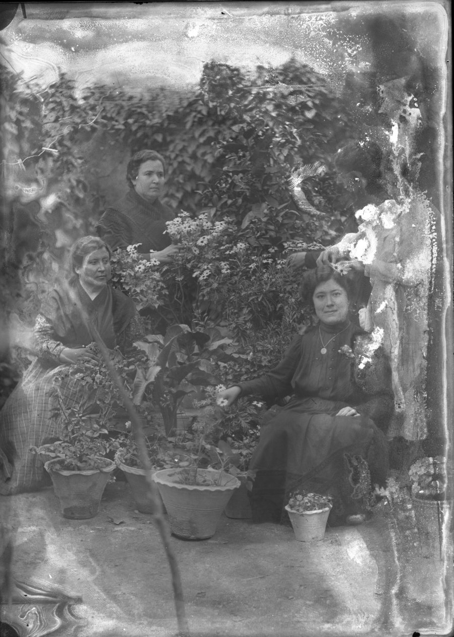 Retrato de cinco mujeres en el patio de una vivienda