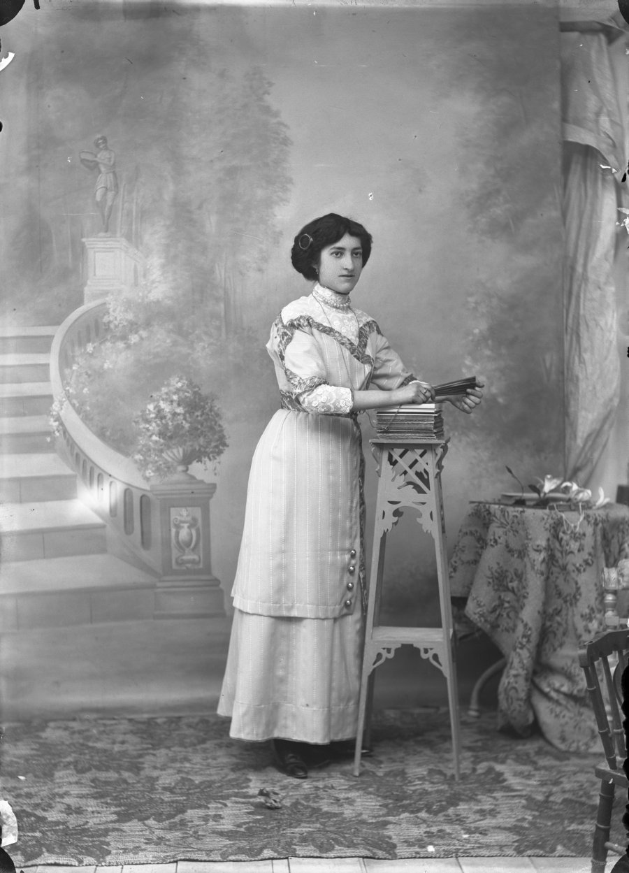 Retrato de estudio de una mujer joven con vestido de rayas y encaje