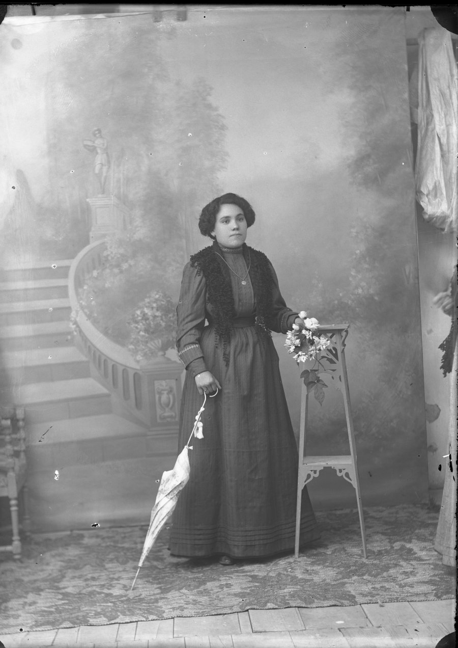 Retrato de estudio de una mujer joven con sombrilla blanca y chal negro