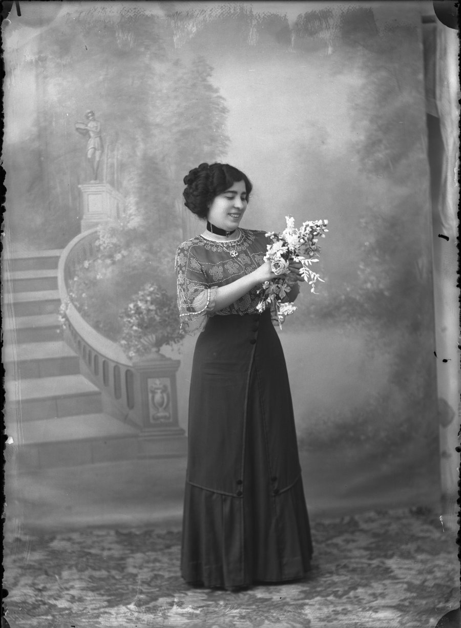 Retrato de estudio de una mujer joven con ramo de flores