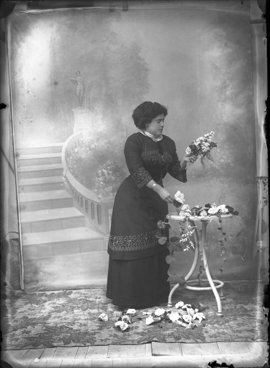 Retrato de estudio de una mujer componiendo un ramo de flores