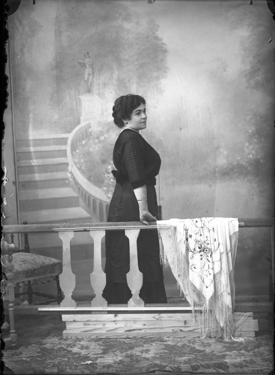 Retrato de estudio de una mujer joven en balcón simulado