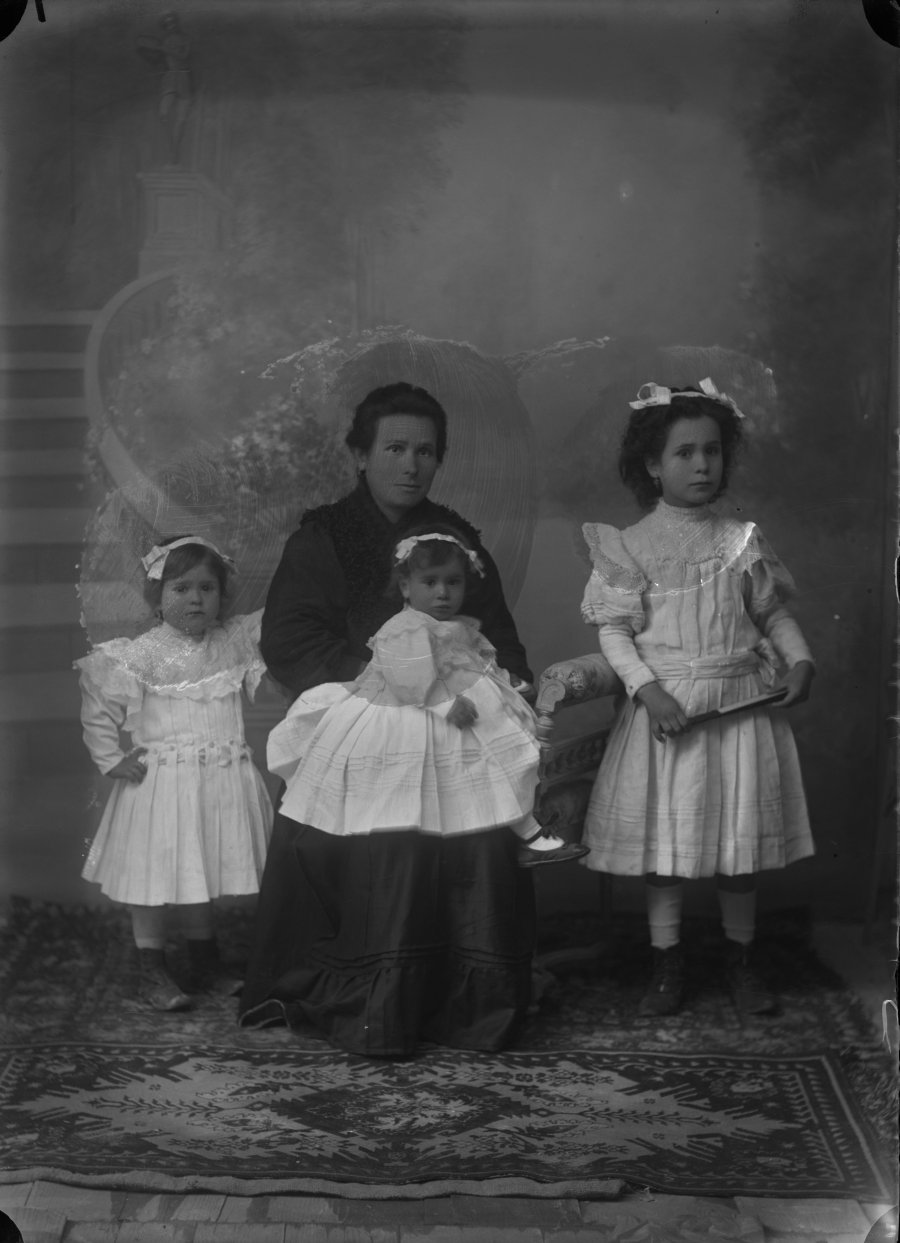 Retrato de estudio de una mujer con sus tres hijas