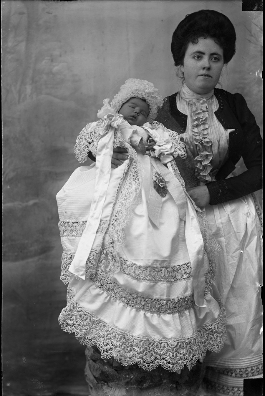 Retrato de estudio de una mujer joven con un bebé de pocos días en brazos