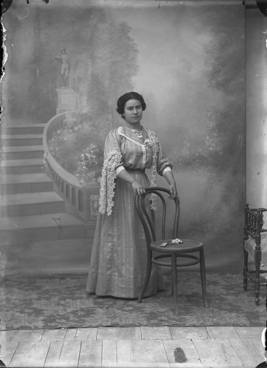 Retrato de estudio de una mujer joven con vestido decorado con encajes de flores