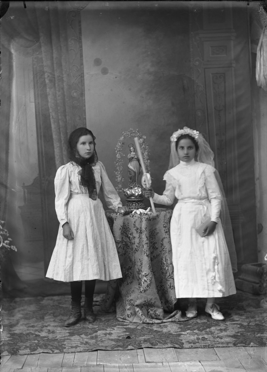 Retrato de estudio de dos niñas de primera comunión, una de ellas con velo negro