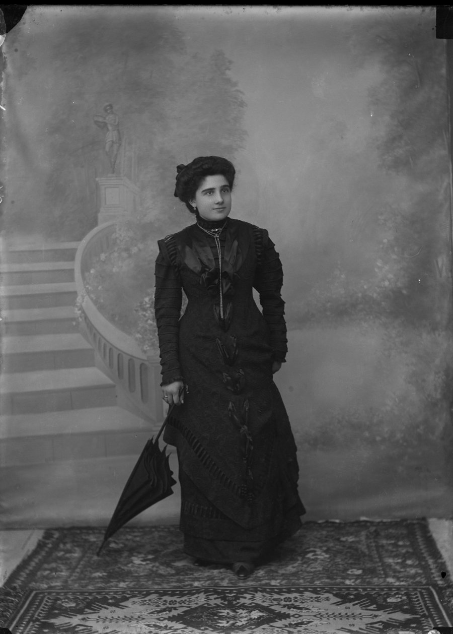 Retrato de estudio de una mujer joven con vestido y sombrilla negros