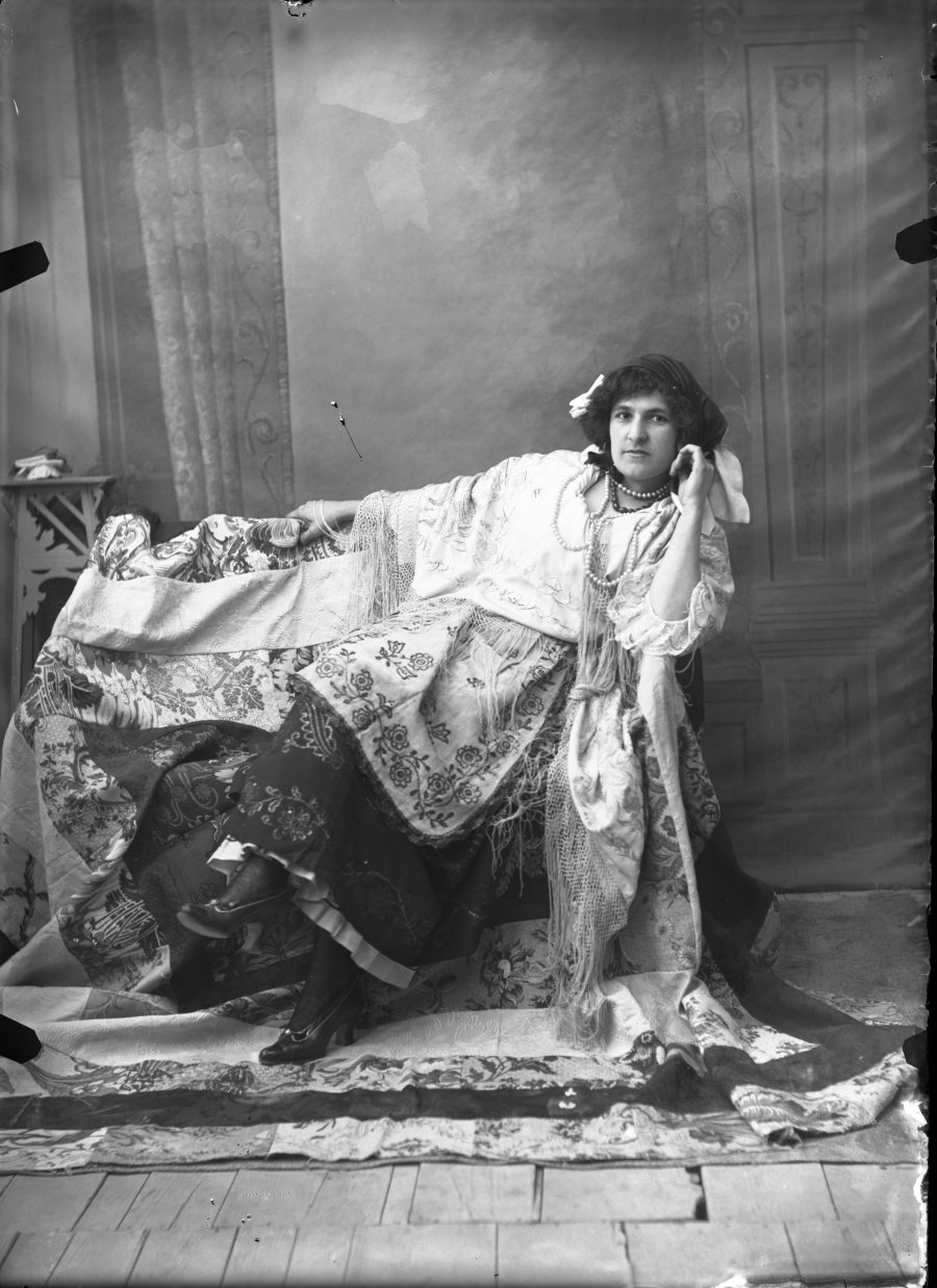 Retrato de estudio de una joven sentada con traje de huertana