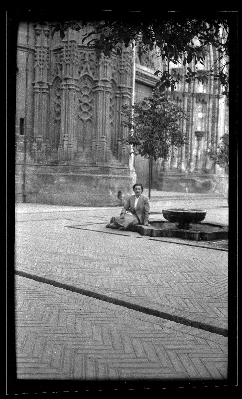 Rosario Isasa sentada junto a una fuente en el Patio de los Naranjos de la Catedral de Sevilla