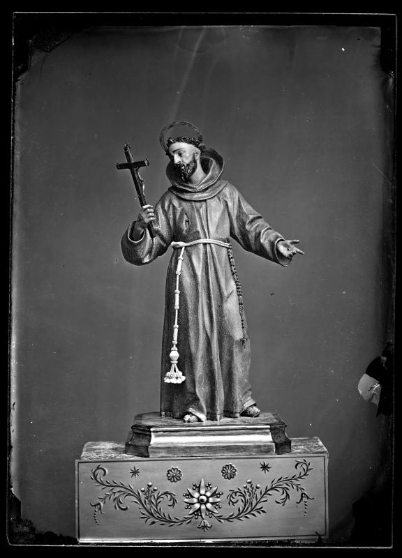 Escultura de San Francisco con un crucifijo en la mano