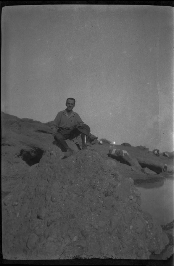Retrato de cuerpo entero de Eduardo Forcén sentado en una zona rocosa de Marruecos