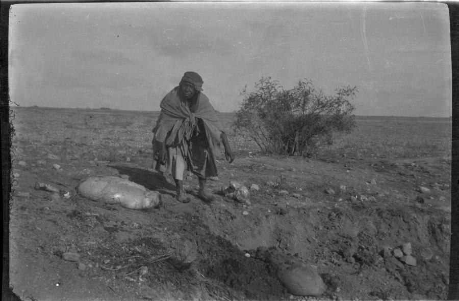 Retrato de un campesino marroquí junto a los restos de un animal en el campo
