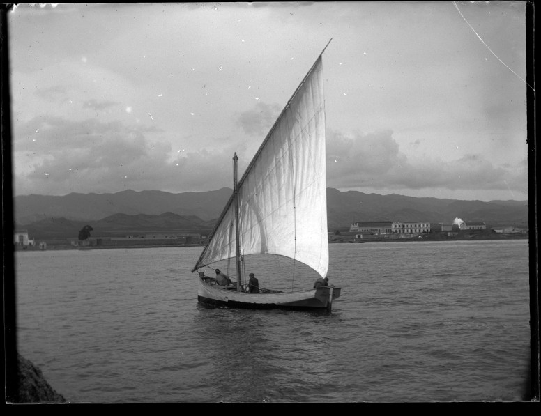 Barco velero con las velas izadas en la bahía de Águilas, visto de popa.