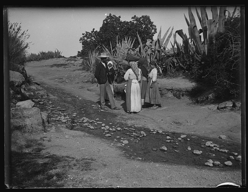 Un hombre conversa con un grupo de mujeres en un camino en los alrededores de Almajalejo.