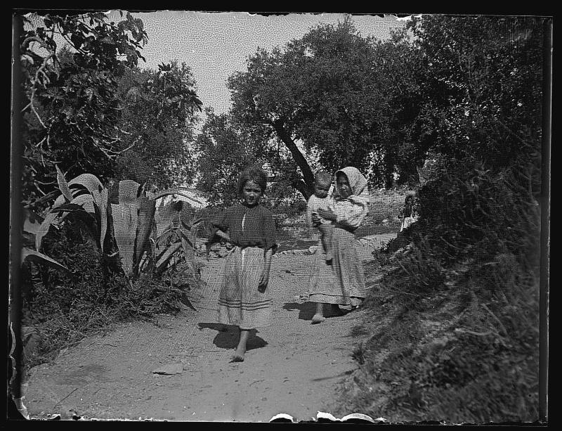 Tres niñas con un bebé en un camino de Almajalejo.