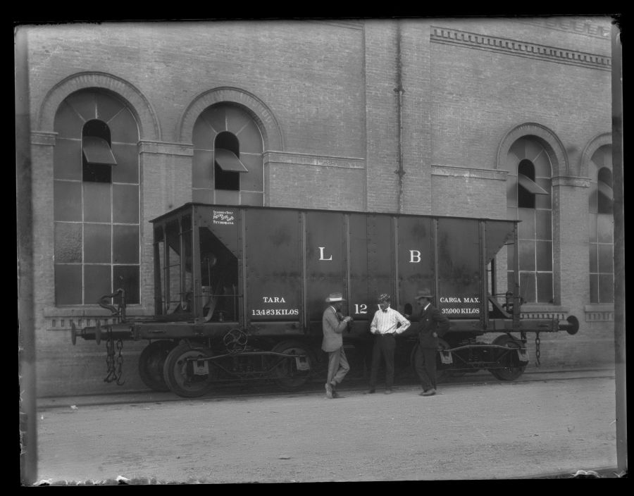 Gustavo Gillman y otros dos empleados británicos junto a uno de los nuevos vagones de carga de mineral, en los talleres ferroviarios de Águilas.