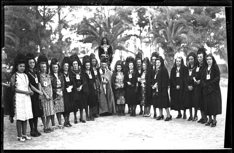 Grupo de señoras con teja y mantilla junto a una imagen del Prendimiento de Cristo, en un parque en Cartagena