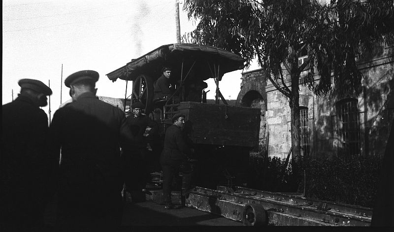 Vista de un vehículo locomóvil sobre raíles izando una carga pesada
