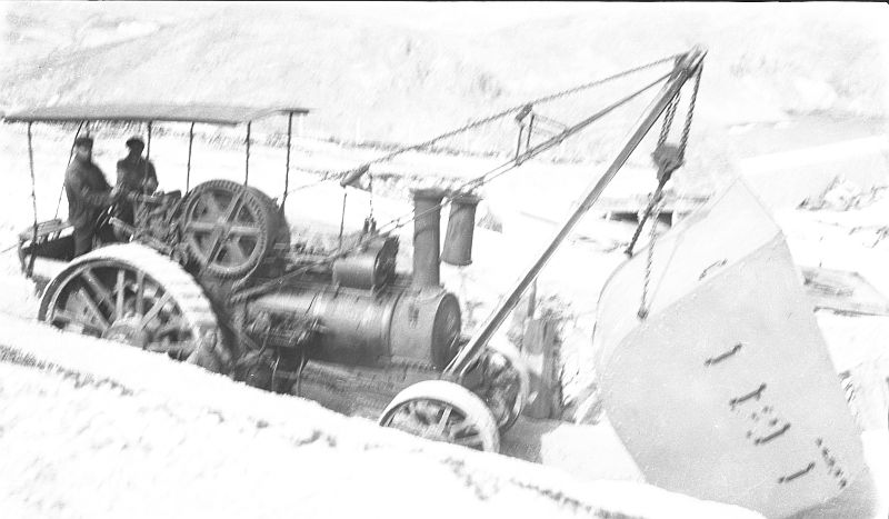 Vista de una grúa locomóvil transportando el escudo protector de una pieza de artillería