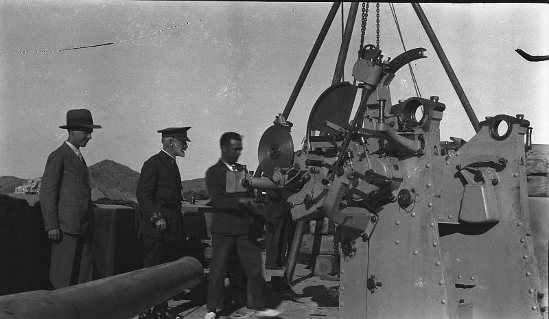 Un coronel y dos civiles supervisan el montaje de un cañón antiaéreo en una batería de costa de Cartagena